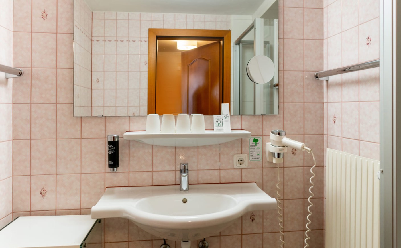 Detailaufnahme des Badezimmers mit Waschplatz und Spiegel im Dreibettzimmer