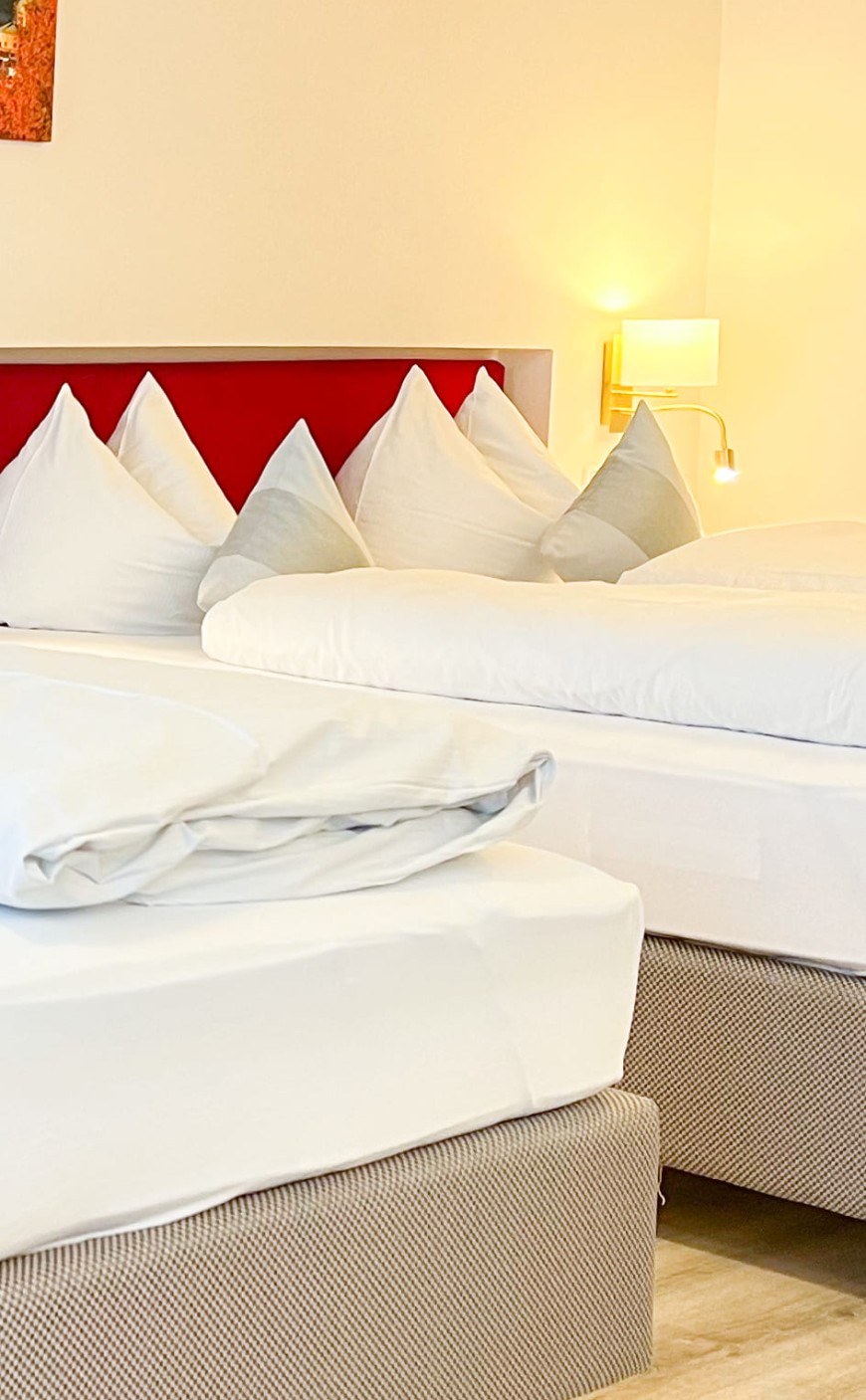Gem&uuml;tliche Schlafatmosph&auml;re im Vierbettzimmer der Trumer Stube Salzburg