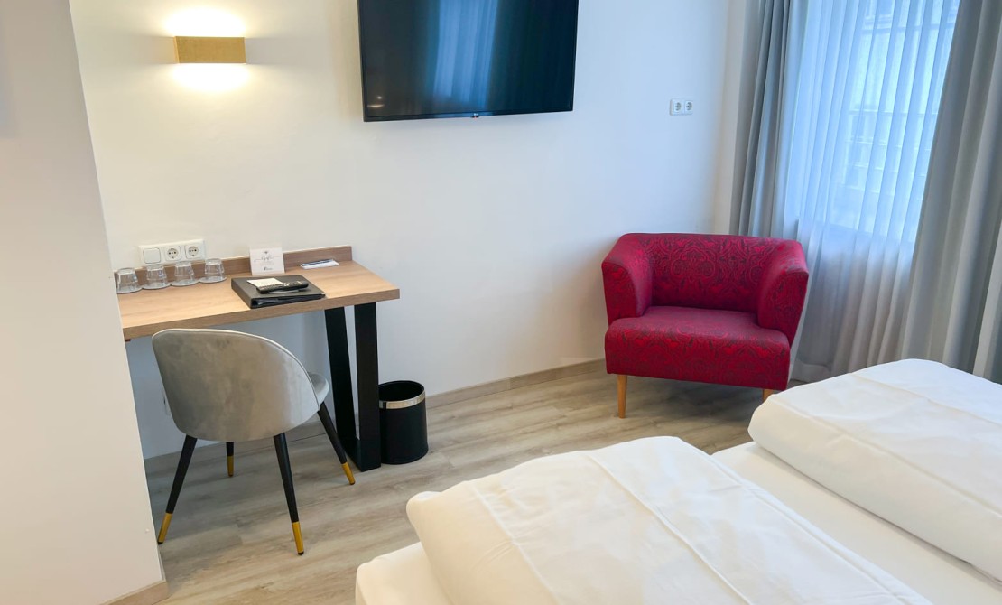 Sitzecke mit Schreibtisch und TV im Vierbettzimmer